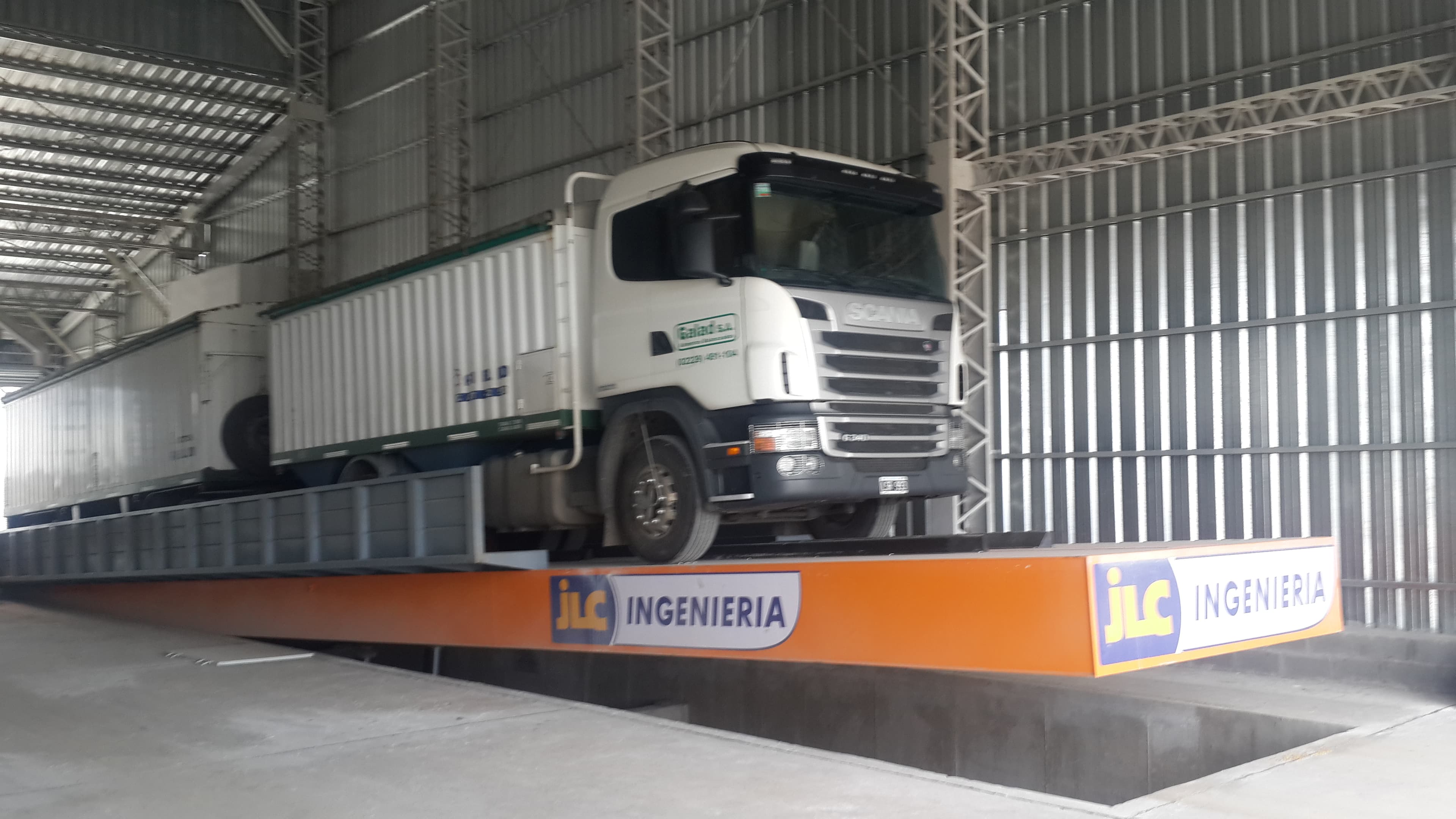 Plataforma volcadora JLC en instalación industrial con camión descargando