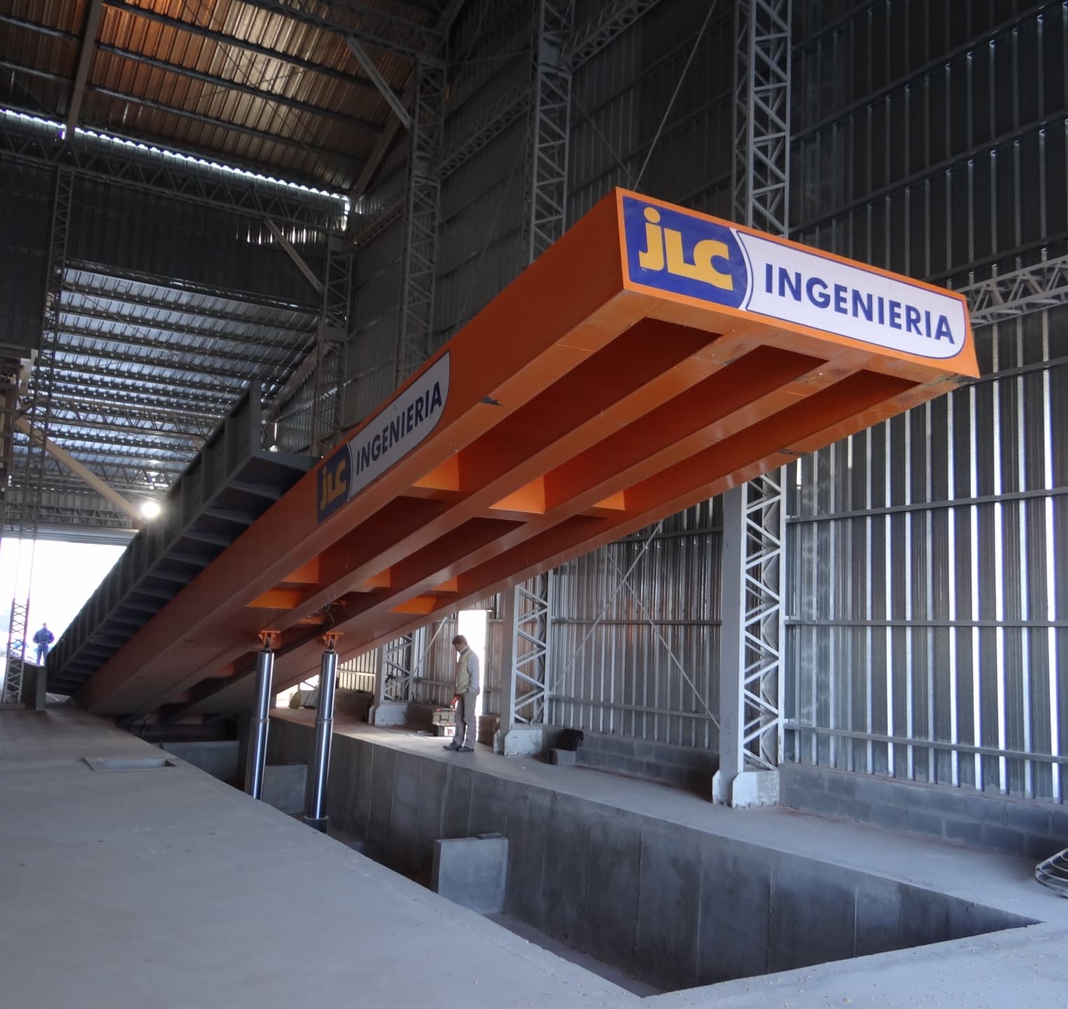 Plataforma volcadora JLC en instalación industrial con camión descargando